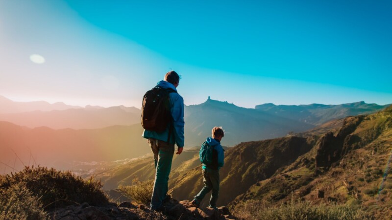 Lifestyle performance training father hiking outdoors with son representing real fitness success and healthy living