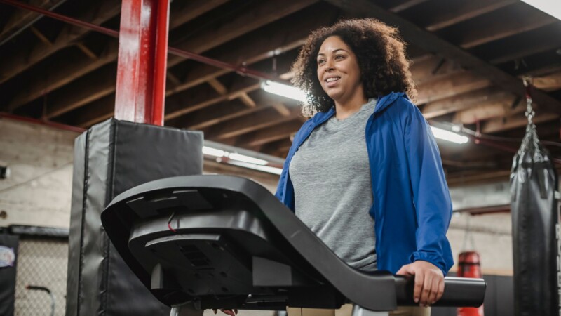woman on treadmill consistently exercising and building healthy habits for long term fitness success